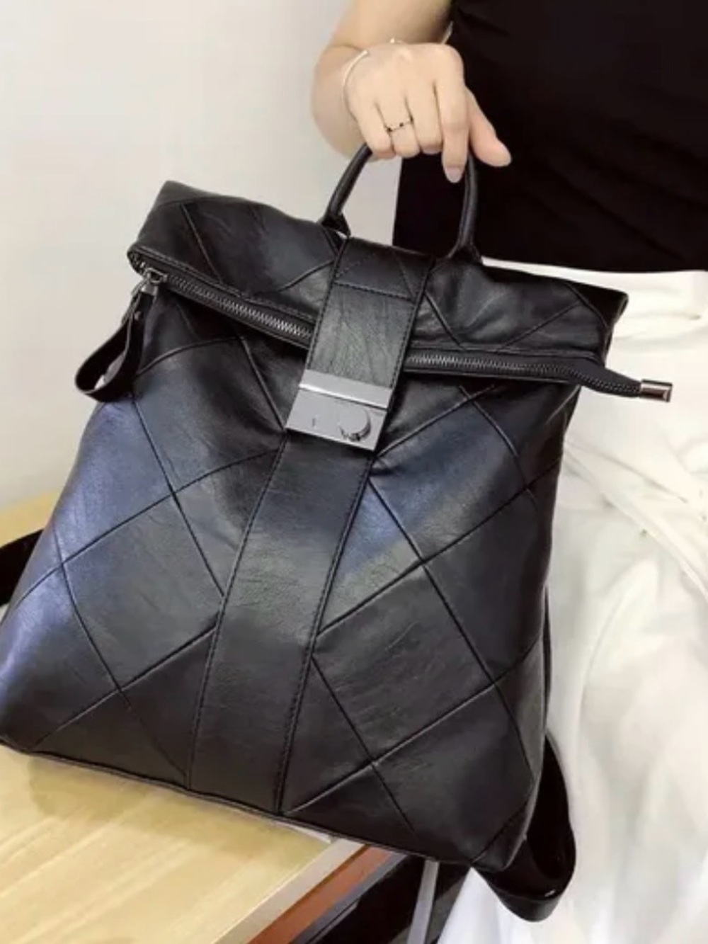 Black Quilted Leather Backpack with Top Handle and Metal Accent